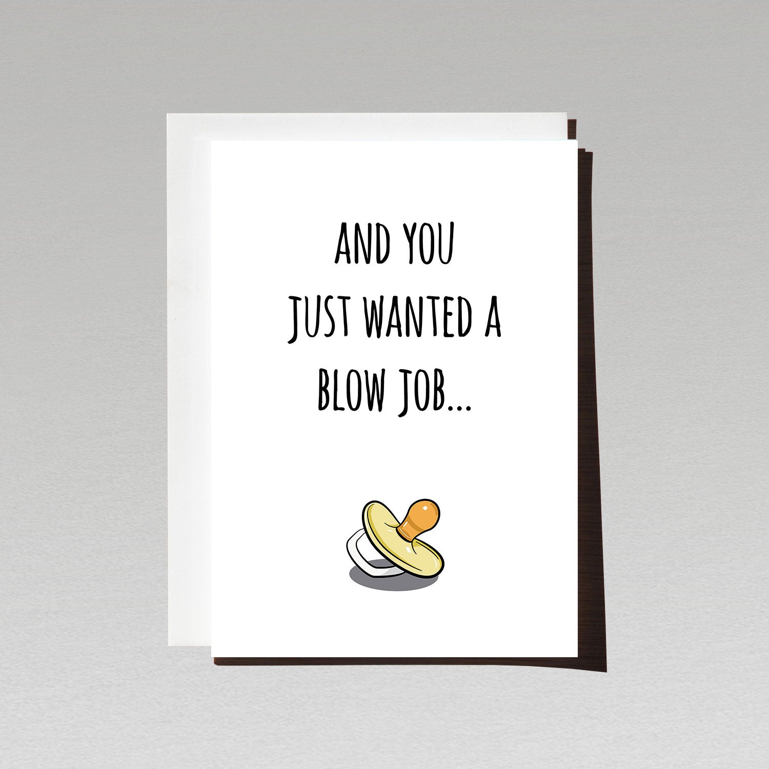 pregnancy reveal greeting card with yellow pacifier on white background with text and you just wanted a blow job
